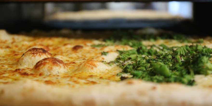 Photo of pizza coming out of the oven at GJP Italian Eatery in Oswego, NY.