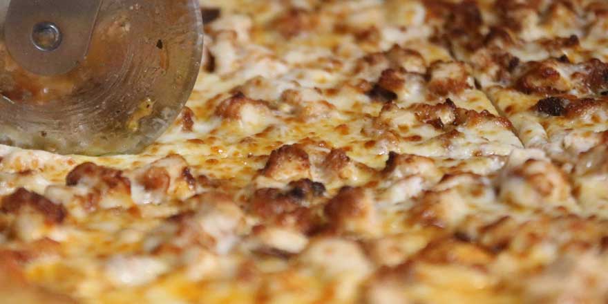 Photo of pizza being sliced for customers at GJP Italian Eatery in Oswego, NY.